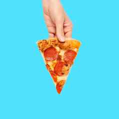 片意大利辣香肠披萨手孤立的蓝色的前视图paperoni披萨概念意大利食物街食物快食物快速咬
