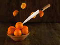 刀切割橙子很多橙子碗黑暗背景生活水果古董风格飞行橙子碗黑暗照片行动移动照片