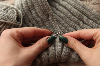 针织年轻的女士手针织针灰色羊毛卷女人手针织
