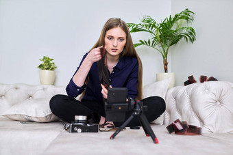年轻的女人摄影师古董相机记录<strong>视频</strong>智能手机
