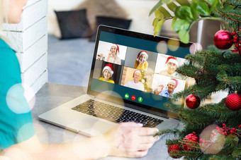 圣诞节在线女人白色毛衣红色的圣诞老人他移动PC使视频调用朋友父母在线购物