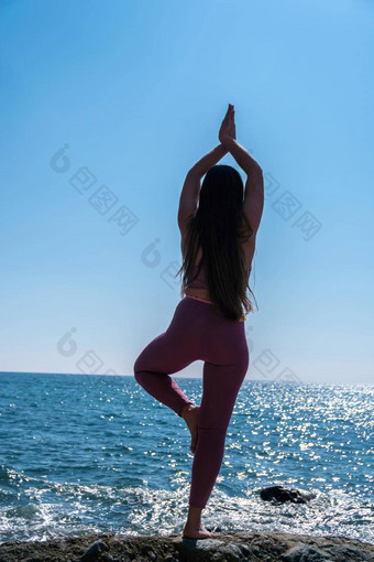 年轻的女人长头发健身教练运动服装<strong>紧身</strong>裤<strong>上衣</strong>伸展运动普拉提瑜伽席海阳光明媚的一天女健身瑜伽例程概念