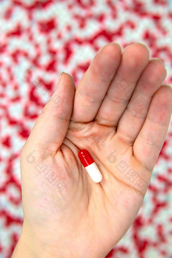 手持有红色的白色胶囊药物治疗维生素药物背景白色背景前视图平躺复制空间关闭医学业务健康概念