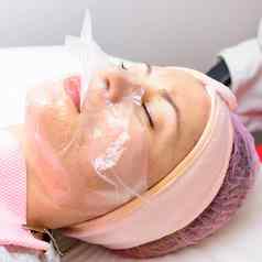 透明的mask-film脸女人访问美容师面部护理