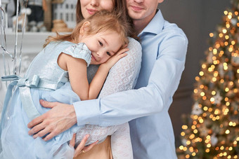 爱的家庭妈妈爸爸拥抱女儿父<strong>母婴</strong>儿孩子有趣的圣诞<strong>节</strong>树白色壁炉在室内快乐圣诞<strong>节</strong>快乐一年快乐的漂亮的人