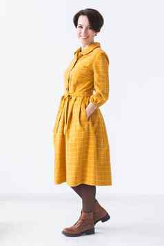 服装设计师人概念有吸引力的女人黄色的衣服摆姿势白色房间