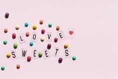 分类甜蜜的糖果粉红色的背景色彩斑斓的糖果文本爱糖果平躺作文果冻豆子色彩斑斓的巧克力糖果巧克力按钮
