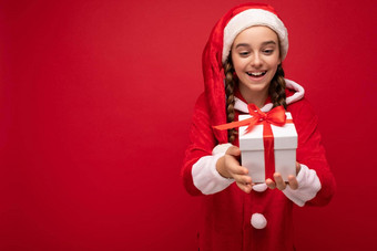 拍摄美丽的快乐微笑浅黑肤色的女人女孩孤立的<strong>红</strong>色的<strong>背景墙</strong>穿一年圣诞老人老人装持有白色礼物盒子<strong>红</strong>色的丝带