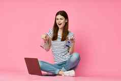 女人移动PC粉红色的背景在线购物娱乐