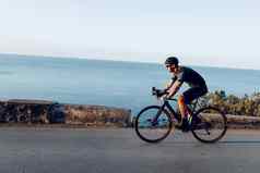 骑自行车体育运动运动员男人。骑沿海路