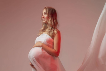 优雅的怀孕了年轻的女人站穿光织物怀孕幻想仙女演讲概念