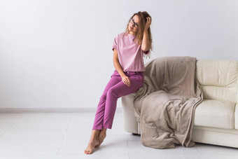 年轻的有吸引力的女人穿着美丽的色彩斑斓的睡衣摆姿势模型生活房间舒适的睡衣裤首页放松女时尚概念
