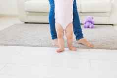 步骤婴儿蹒跚学步的学习走白色阳光明媚的生活房间鞋子孩子