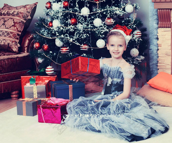 女孩坐着圣诞节树大礼物