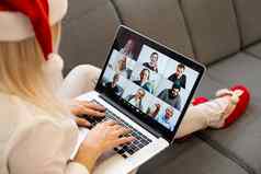 年轻的微笑女人穿红色的圣诞老人老人他使视频调用社会网络家庭朋友圣诞节一天