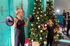 肖像健康的女女儿练习物理锻炼圣诞节树