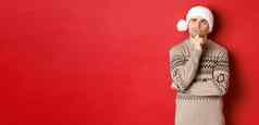 图像有吸引力的男人。圣诞节毛衣圣诞老人他思考一年礼物上左角落里深思熟虑的站红色的背景