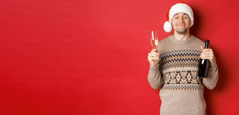 概念冬天假期圣诞节庆祝活动图像很高兴微笑男人。圣诞老人他毛衣喝一年持有瓶香槟填满玻璃红色的背景