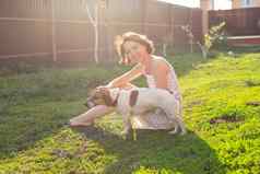 纤细的可爱的年轻的女人戏剧亲爱的有趣的狗院子里阳光明媚的夏天一天可爱的宠物概念