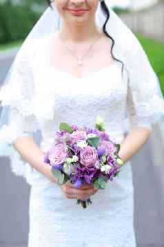 新娘保持紫罗兰色的花束花