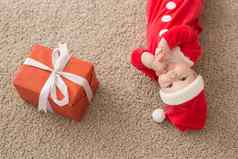美丽的婴儿庆祝圣诞节一年的假期婴儿圣诞节服装圣诞老人他礼物盒子前视图