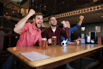 看足球酒吧快乐朋友喝啤酒欢呼最喜欢的团队庆祝胜利