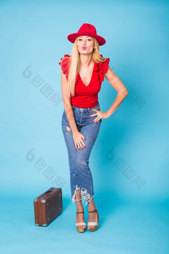 夏天旅行人假期概念时尚年轻的金发碧眼的女人复古的手提箱孤立的蓝色的背景