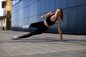 健身女人运动服装一边板材锻炼在户外