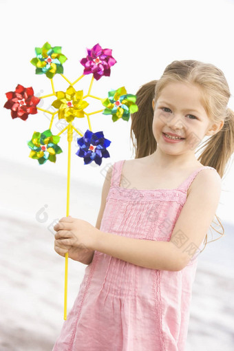 年轻的女孩海滩玩具风车微笑
