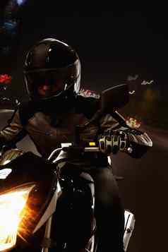 年轻的男人。骑摩托车晚上街道北京