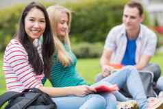年轻的大学学生坐着公园