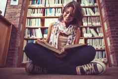 快乐女学生书架上阅读书图书馆地板上