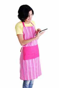 年轻的女人粉红色的围裙平板电脑电脑