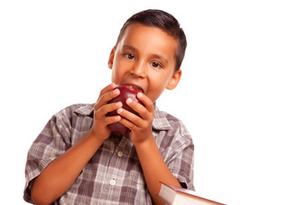 可爱的拉美裔男孩吃大红色的苹果
