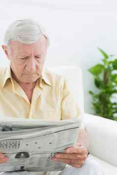 上了年纪的集中男人。阅读报纸