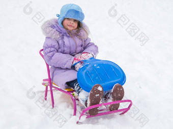 快乐的女孩坐着雪橇
