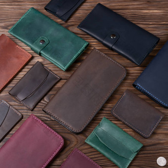 棕色（的）颜色手工制作的皮革钱包包围皮革配件木变形背景一边视图股票照片奢侈品配件