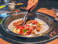 女手烹饪朝鲜文烤肉烤 架牛肉烧烤烧烤餐厅表格