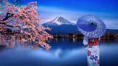 亚洲女人穿日本传统的和服富士山樱桃开花河口湖湖日本