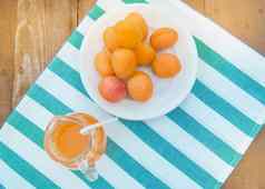 夏天喝新鲜水果杏汁玻璃壶成熟的杏子餐巾前视图户外