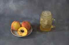 成熟的多汁的桃子陶瓷板杯子桃子汁冰灰色的摘要背景特写镜头