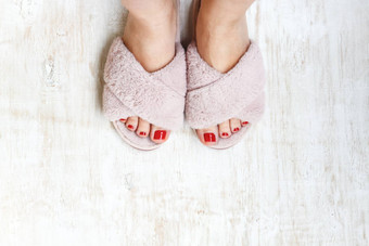 女腿红色的指甲首页皮毛毛茸茸的粉红色的拖鞋