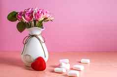 小白色粉红色的棉花糖分散苍白的粉红色的背景花瓶玫瑰的地方文本