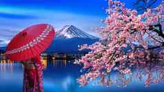 亚洲女人穿日本传统的和服富士山樱桃开花河口湖湖日本