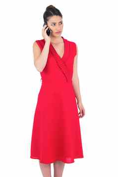 优雅的浅黑肤色的女人红色的衣服电话摆姿势