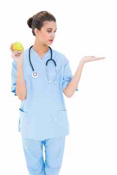漂亮的棕色（的）头发的护士蓝色的实习医生风云持有绿色苹果