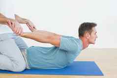 物理治疗师协助男人。伸展运动练习