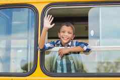 肖像小学生挥舞着手公共汽车