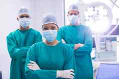 团队外科医生穿外科手术面具操作剧院