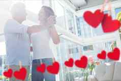 复合图像挂红色的心成熟的夫妇跳舞